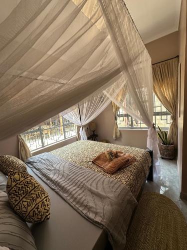a bedroom with a canopy bed with a tray on it at Meru Nest Arusha in Arusha