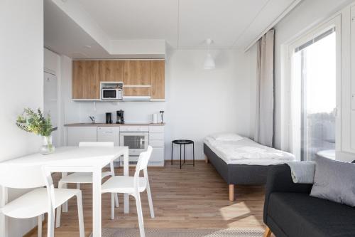 a kitchen and living room with a table and a couch at Spot Apartments Oulu in Oulu
