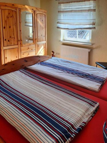 a bed with a large striped blanket on it at Haus Petra in Gleishorbach