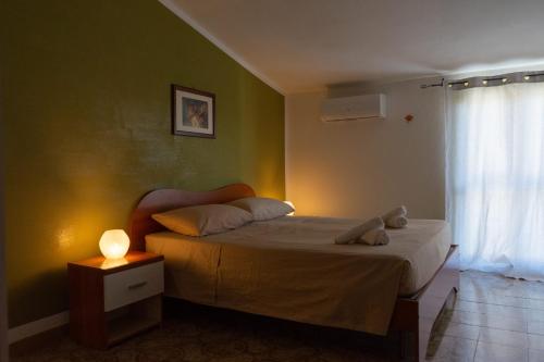 a bedroom with a bed with a lamp and a window at Casa di Nonna Nì - Due alloggi con scala interna condivisa in Portocannone