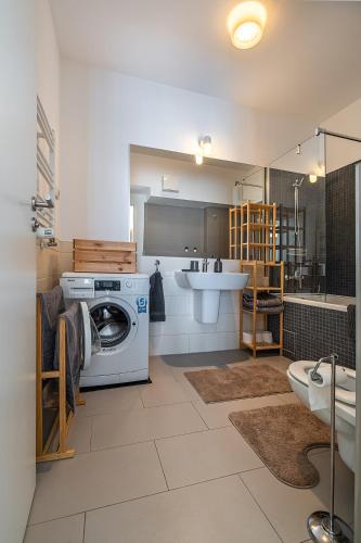 a bathroom with a washing machine and a sink at GreenVista 20 minutes by Therme & Airport in Voluntari