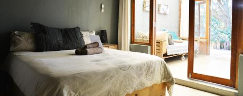 a bedroom with a bed with a white comforter at The Prawn Hatchery Pty Ltd on Amatikulu in Dokodweni