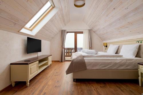a bedroom with a large bed and a television at Licorna La Vie in Gura Vadului