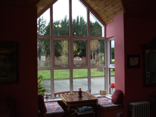 a room with a large window with a table in front at Maple Lodge in Wexford