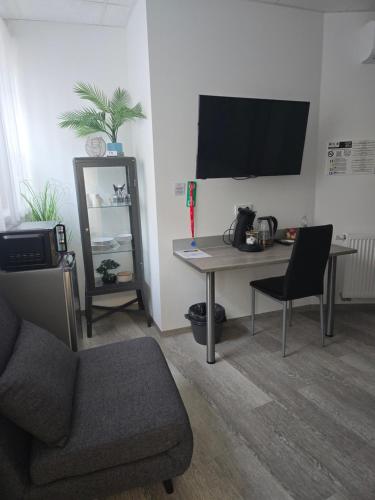 a living room with a desk with a chair and a tv at Offbase Lodging No6 in Ramstein-Miesenbach