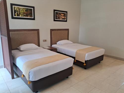 two beds in a hotel room with two beds at INDO ALAM RECREATIONAL RESORT in Sindanglaya