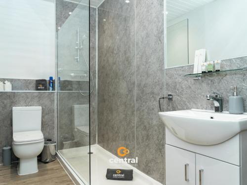 a bathroom with a shower and a toilet and a sink at The Bond by CENTRAL SERVICED APARTMENTS - 2 Bedrooms - 3 Double Beds - Walk Away From City Centre & Universities - Walk away from Bus & Train Station & Waterfront - Short & Long Stays Accomodated in Dundee