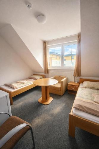 a room with two beds and a table and a window at REVIS Tachov in Tachov