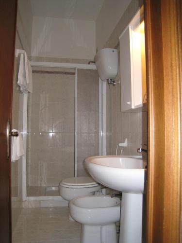 a bathroom with a sink and a toilet and a shower at Rugiada Rooms in Rivotorto