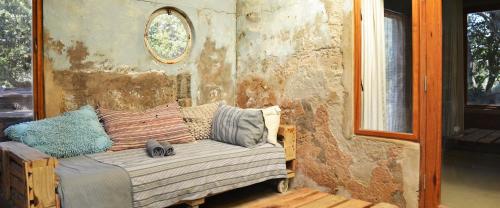 a small couch in a room with a stone wall at The Prawn Hatchery Pty Ltd on Amatikulu in Dokodweni