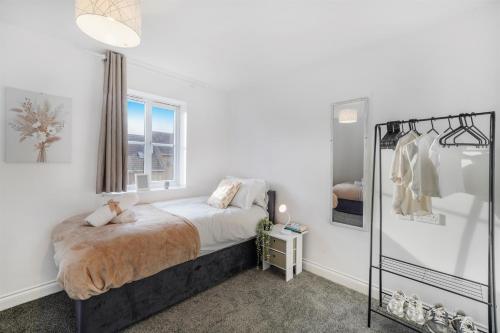 a white bedroom with a bed and a window at 3 BR 6 Beds 3 Bath Garden Parking Heathrow 15 min Windsor & Legoland in Langley Marish