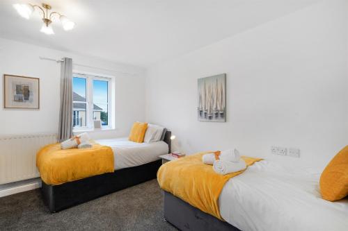 a bedroom with two beds and a window at 3 BR 6 Beds 3 Bath Garden Parking Heathrow 15 min Windsor & Legoland in Langley Marish