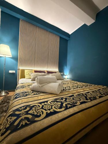 a blue bedroom with a bed with towels on it at AMA Esclusive SPA Ariosto in Ferrara
