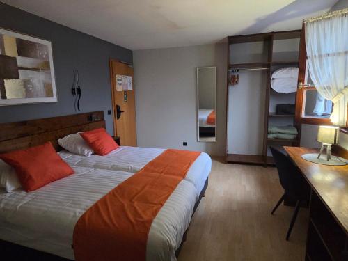 a hotel room with a bed and a desk at Hôtel Restaurant AU SOLEIL in Wahlbach