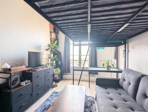un soggiorno con un divano e un tavolo di Beau studio confortable a Parigi