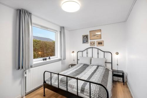 a bedroom with a bed and a window at Feriehus Oluf in Ålbæk