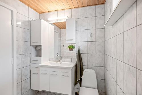 a white bathroom with a sink and a toilet at Feriehus Oluf in Ålbæk