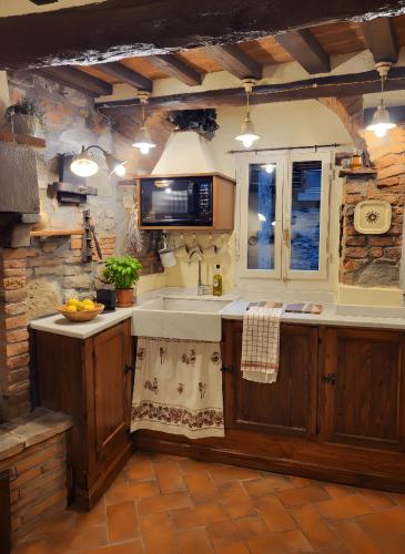 a kitchen with a sink and a microwave at Casa della Rosa in Cortona