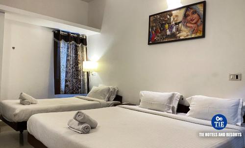 a hotel room with two beds and a picture on the wall at Townhouse 4bhk Bungalow - TIE Hotels in Pondicherry