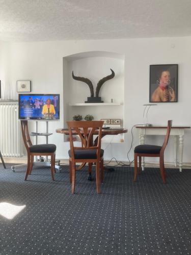 a living room with a table and two chairs and a television at Mosel-Studio-Apartment in Lieser