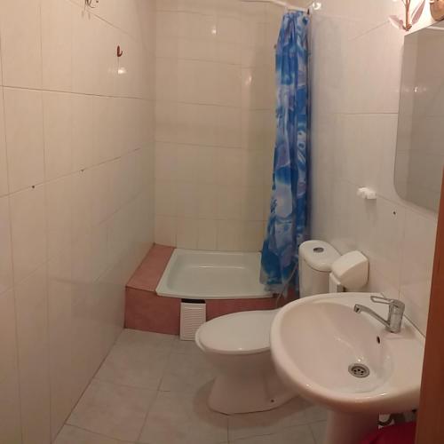 a bathroom with a toilet and a sink and a tub at Бирюза in Karolino-Buhaz