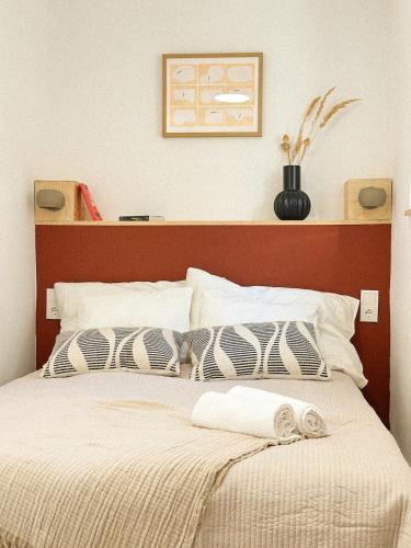 a bed with a wooden headboard with two pillows on it at Lombtér in Pásztó
