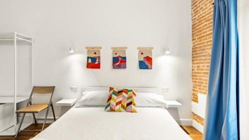 a bedroom with a bed and paintings on the wall at Ceramic Rooms in Oristano
