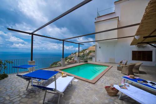 a swimming pool on a patio with a view of the ocean at House Teresa - private pool in Praiano