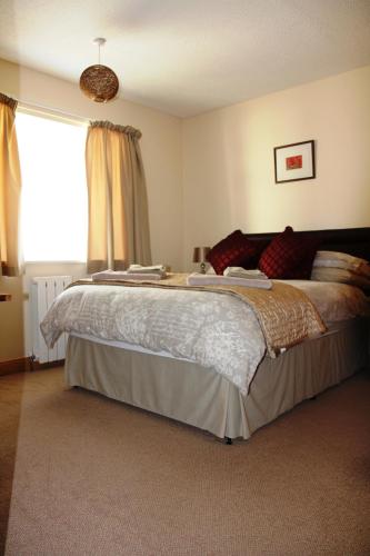 a bedroom with a large bed in front of a window at Briquet Cottages, Guernsey,Channel Islands in St Saviour Guernsey