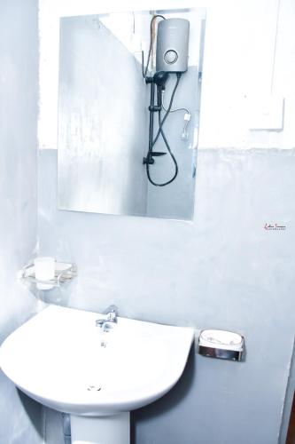 a bathroom with a white sink and a mirror at ELOP Resturant & Villa in Piyadigama