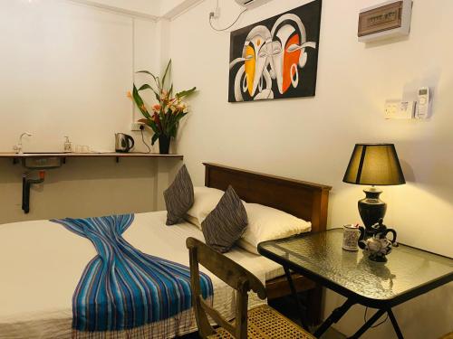a bedroom with a bed and a table with a lamp at ELOP Resturant & Villa in Piyadigama