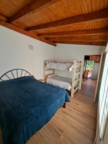 a bedroom with a bed and a wooden ceiling at cabaña los ulmos in Lago Ranco