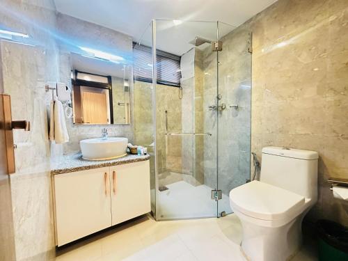 a bathroom with a shower and a toilet and a sink at Hotel Tenki Kathmandu in Kathmandu