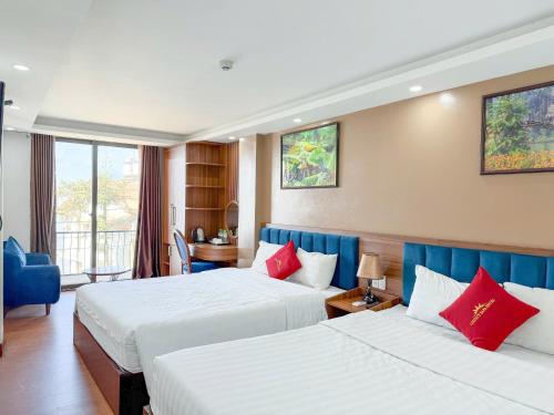 a hotel room with two beds with red pillows at Liberty Sapa Hotel in Sapa