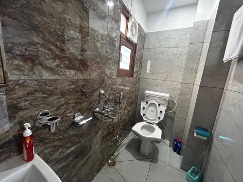 a bathroom with a toilet and a sink at Uttarayan The Homestay in Almora