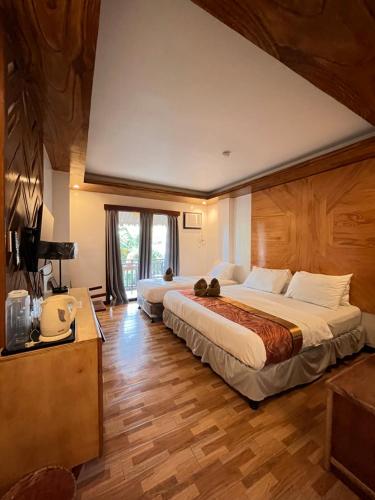 a hotel room with two beds and a window at Puyo Suites Homestay in General Luna