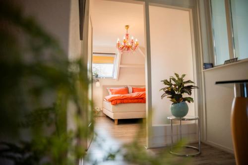 a living room with a couch and a chandelier at de lange adem in Millingen aan de Rijn