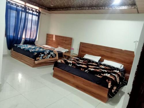 two beds sitting in a room withermottermott at Hotel Radha Krishana in Māna