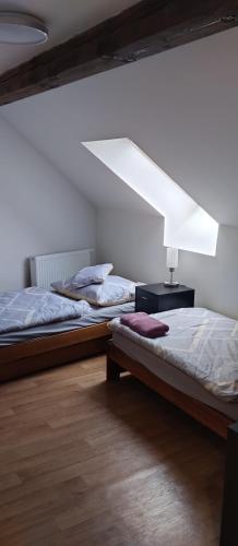 two beds sitting in a room with a light at Pension u Veverků in Protivanov