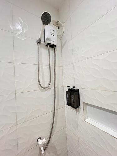 a shower in a bathroom with a shower head at Puyo Suites Homestay in General Luna