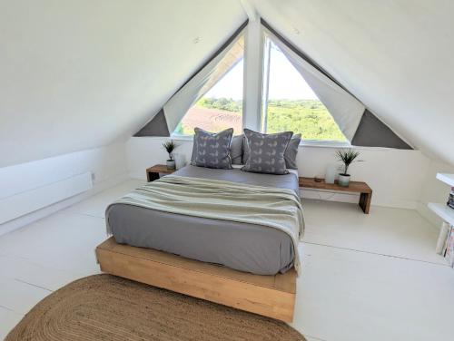 a bedroom with a bed and a large window at Private Double Room and Ensuite in Historic Cornish Cottage in Helston
