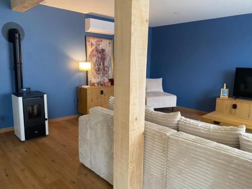 a living room with a couch and a wood stove at La Grange des Pépettes ! in Saint-Germain-des-Fossés
