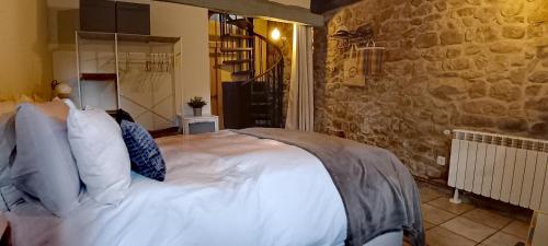 a bedroom with a large bed in a stone wall at Casa el Envero in Saro
