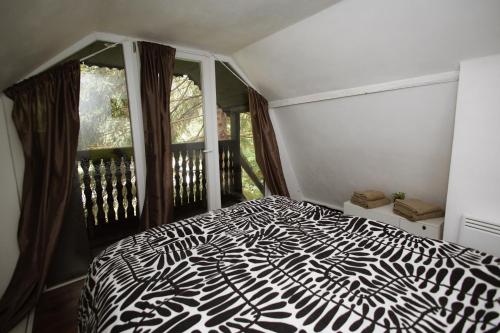 a bedroom with a black and white bed and a window at Sturzul Negru in Păiuş