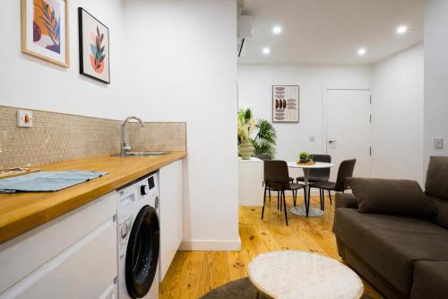 una cucina e un soggiorno con lavatrice e divano di Farrier's Lodge a Gibilterra