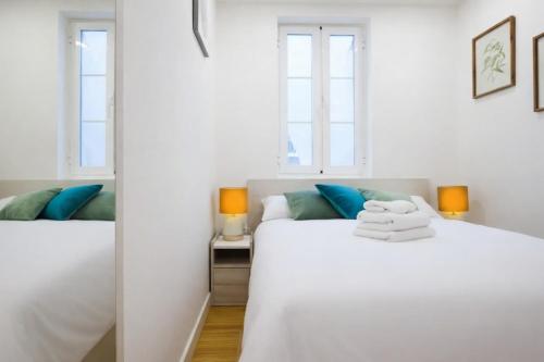 una camera da letto bianca con due letti e due finestre di Farrier's Lodge a Gibilterra