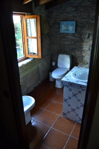 a bathroom with a toilet and a sink at Casa de Fujacos in Valença