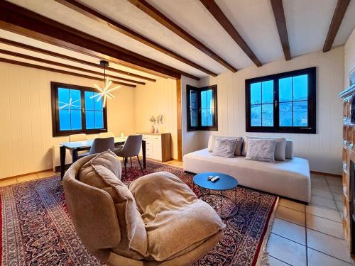 a living room with a couch and a table at Chalet Apartment Faulensee in Faulensee