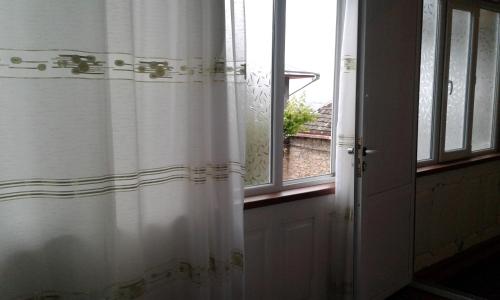 a white shower curtain in front of a window at Ilgar's Hostel in Sheki