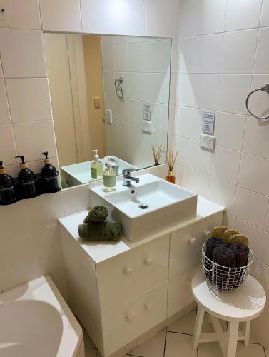 a bathroom with a sink and a mirror at Hamilton Island Poinciana 008 Ground Floor 2bedrooms Free Buggy in Hamilton Island